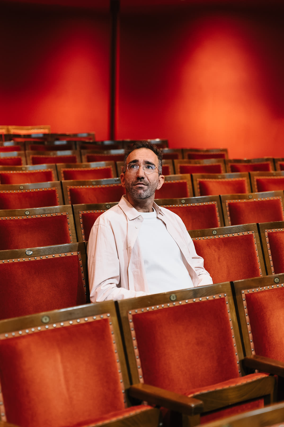 Bedou dans les fauteuils de velours rouge du Jeu de Paume, le regard levé